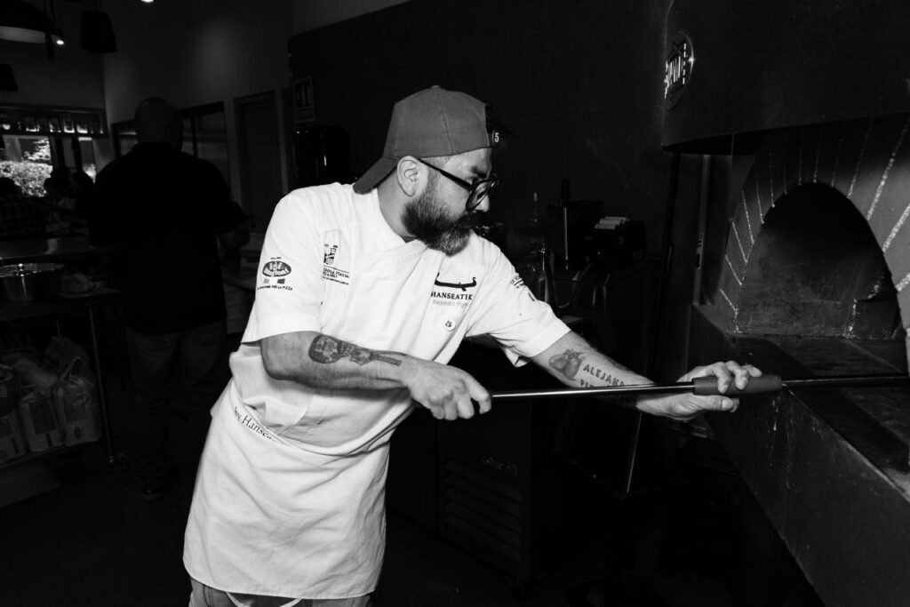 Maestro pizzaiolo horneando.