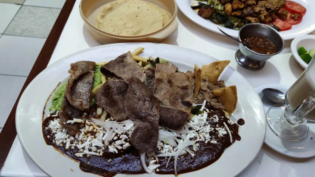 Enmoladas servidas con carne y totopos de Café La Pagoda otro de los lugares 24 horas de CDMX.