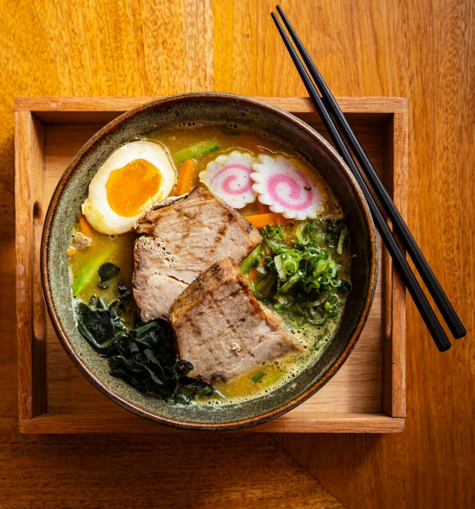 Plato de ramen con carne, fideos, huevo. naruto y verduras de Deigo Ramen.