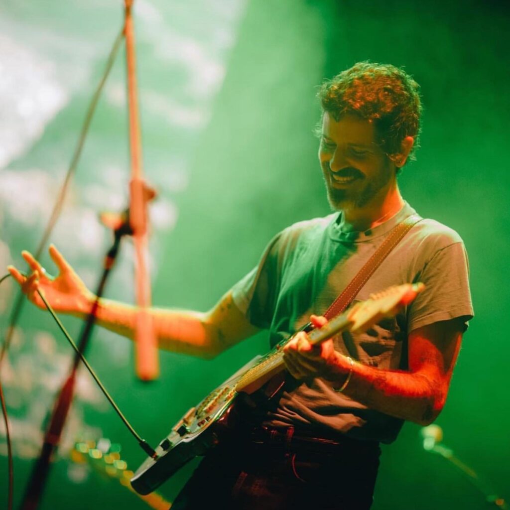 Devendra Banhart tocando su guitarra en un concierto.
