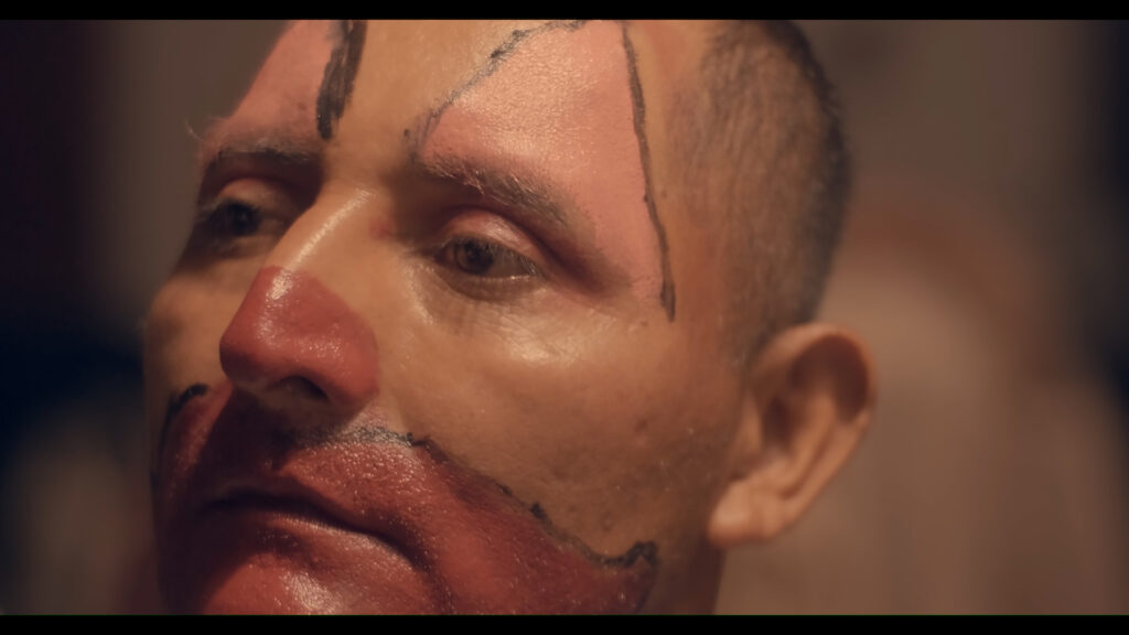 Hombre pintado de payaso en escena de la película Río de Sapos, parte de la programación del Día Nacional del Cine Mexicano.