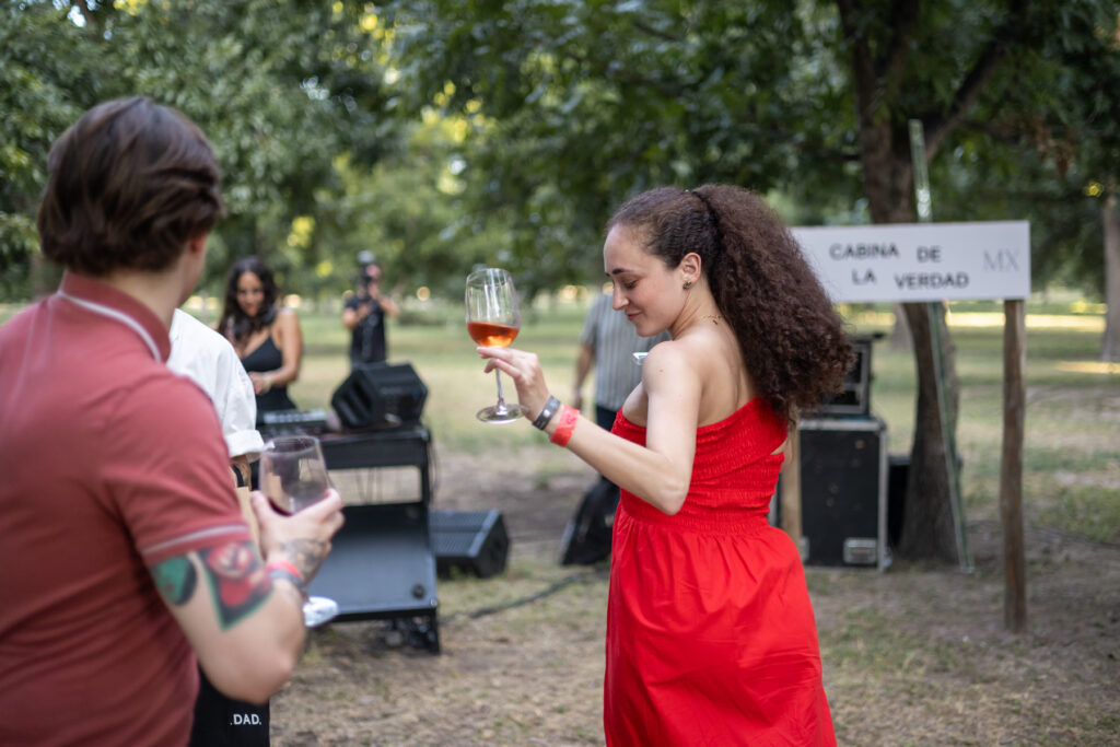 Mujer bailando con una copa de vino en el festival vitivinícola.