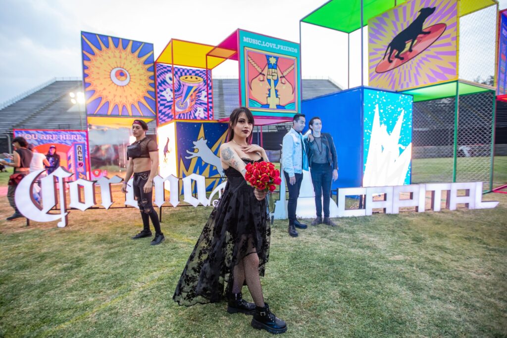 Mujer vestida de negro con un ramo de rosas rojas en la mano.