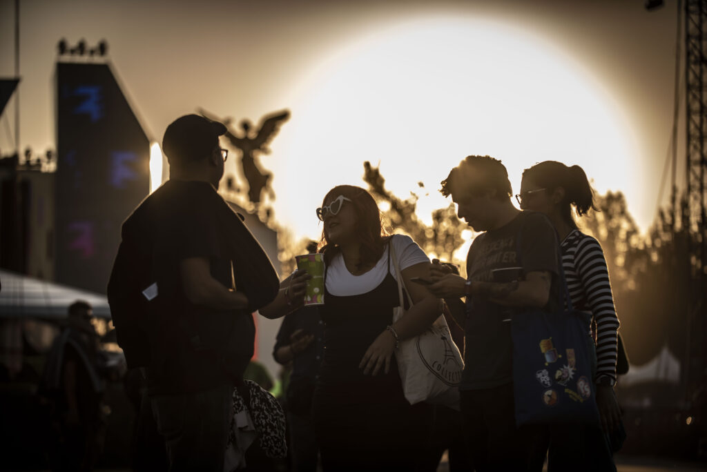 Jovenes con el atardecer de fondo durante el festival.