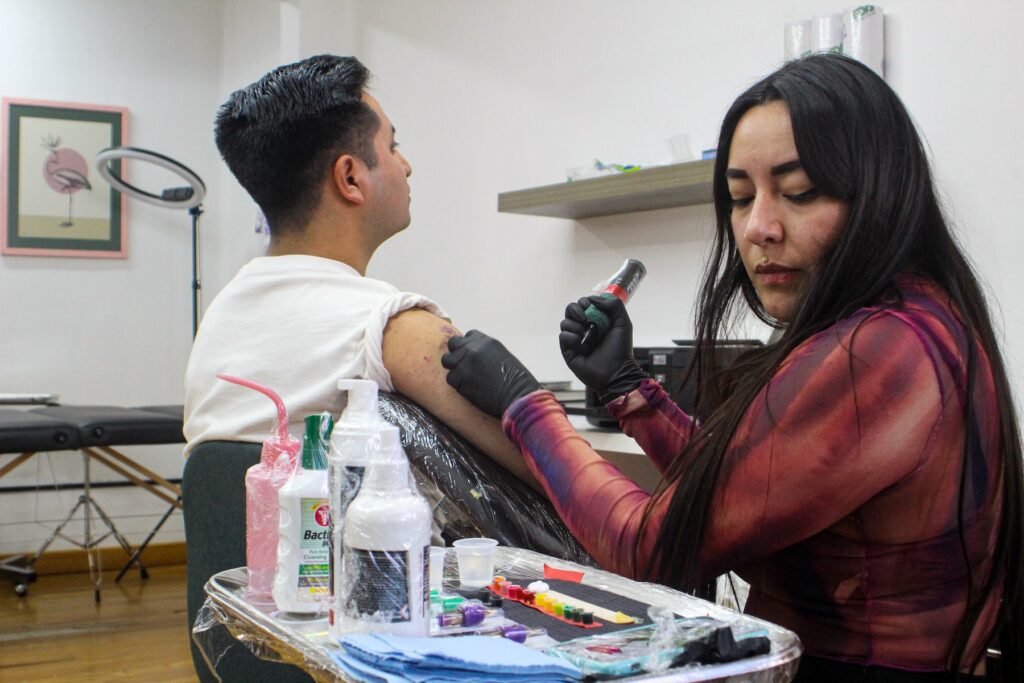 Tatuadora de Soy Feliz Studio haciéndo un tatuaje.
