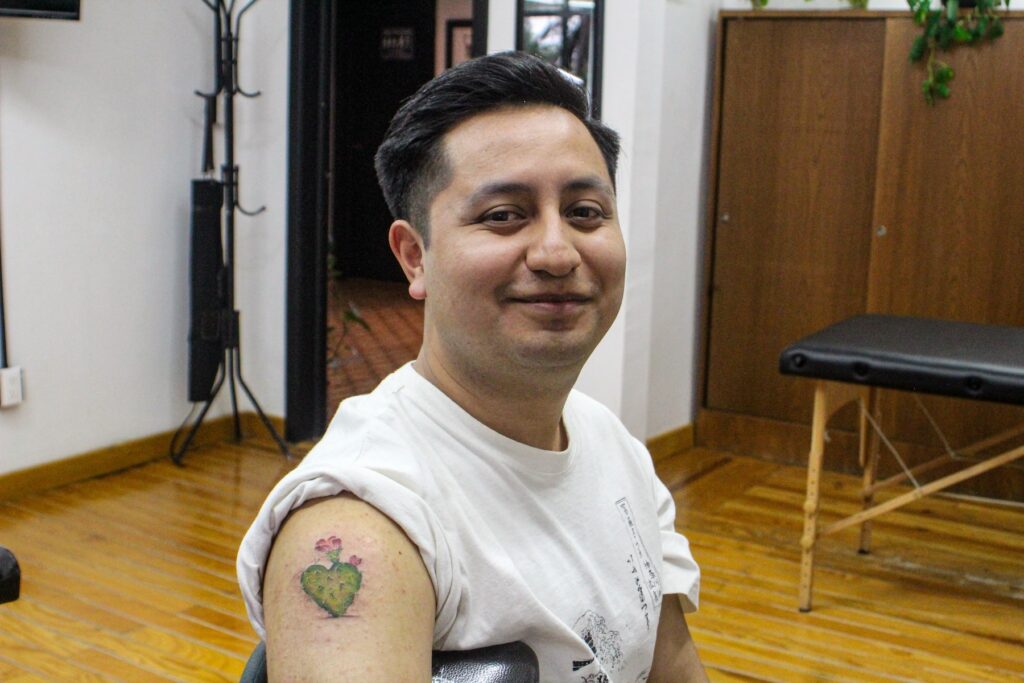 Armando mostrando su tatuaje de nopal en forma de corazón que se hizo para ir gratis al Corona Capital 2025.