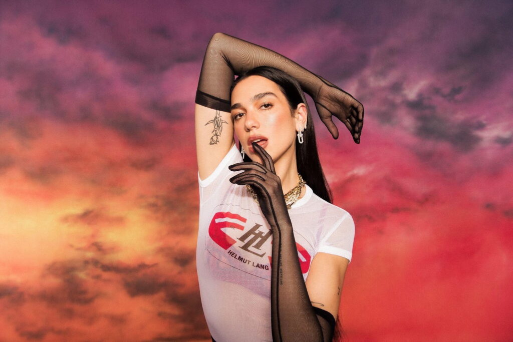 Retrato de Dua Lipa usando una playera blanca y guantes mesh negros.