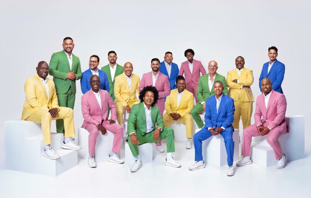 Retrato de Grupo Niche, sus integrantes están usando trajes de colores.