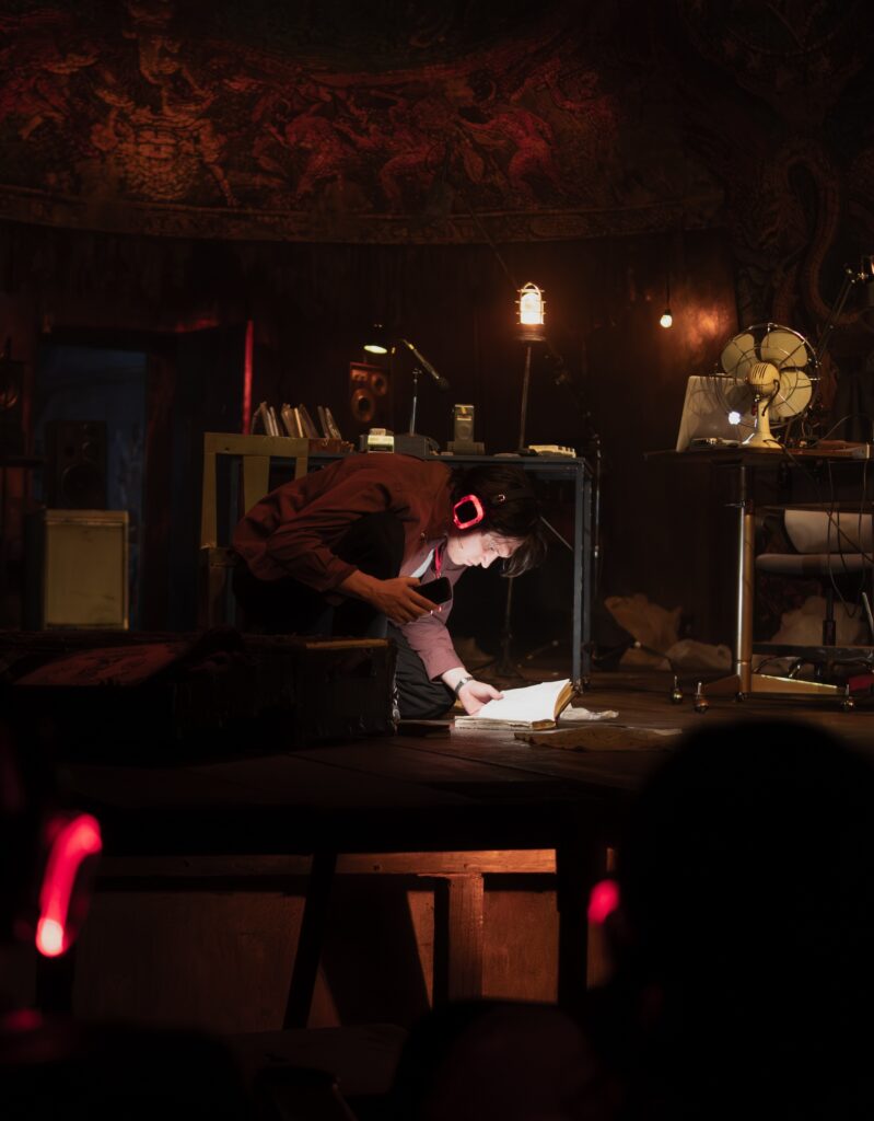 Actor de El episodio maldito en el escenario con mesas, ventiladores y computadoras.