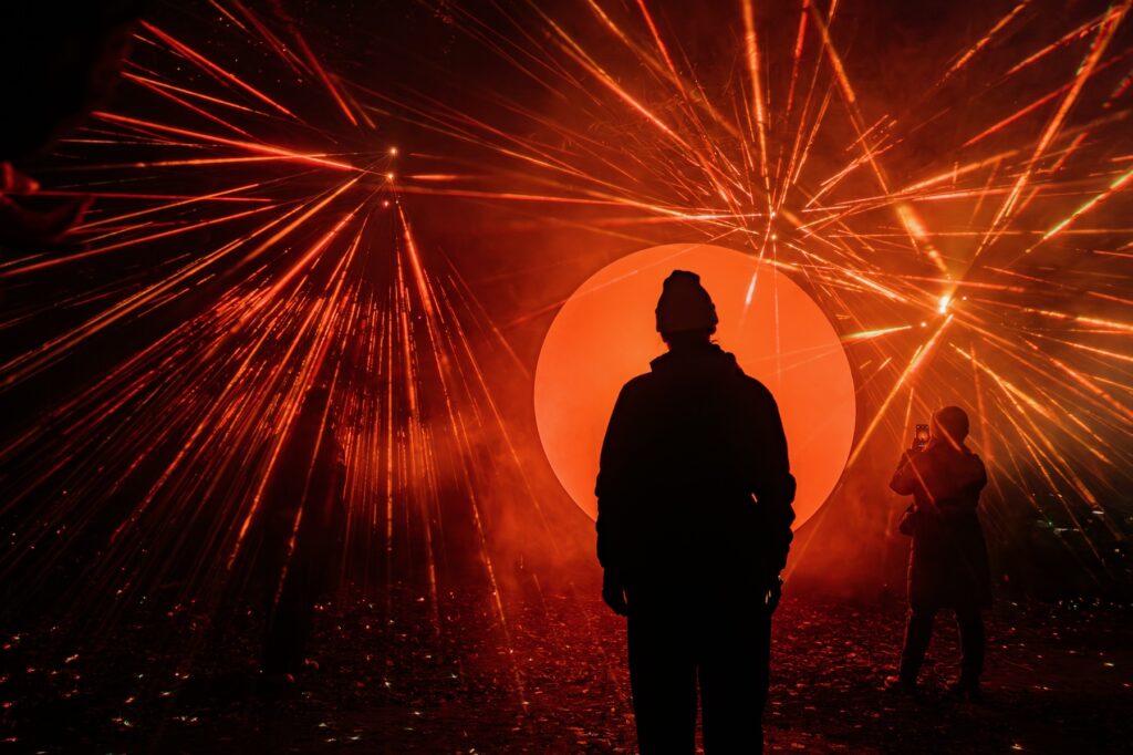 Persona disfrutando del show de luces de Light Cycles en medio de la naturaleza.