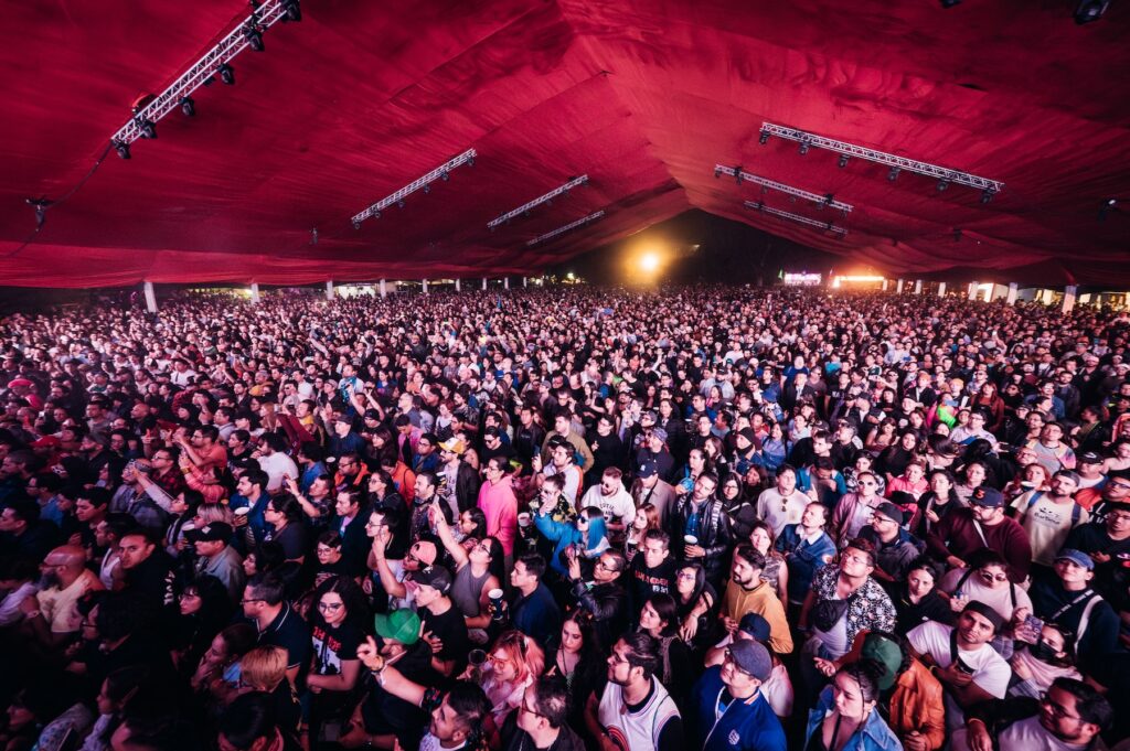 Toma panorámica de los asistentes en el escenario con carpa.