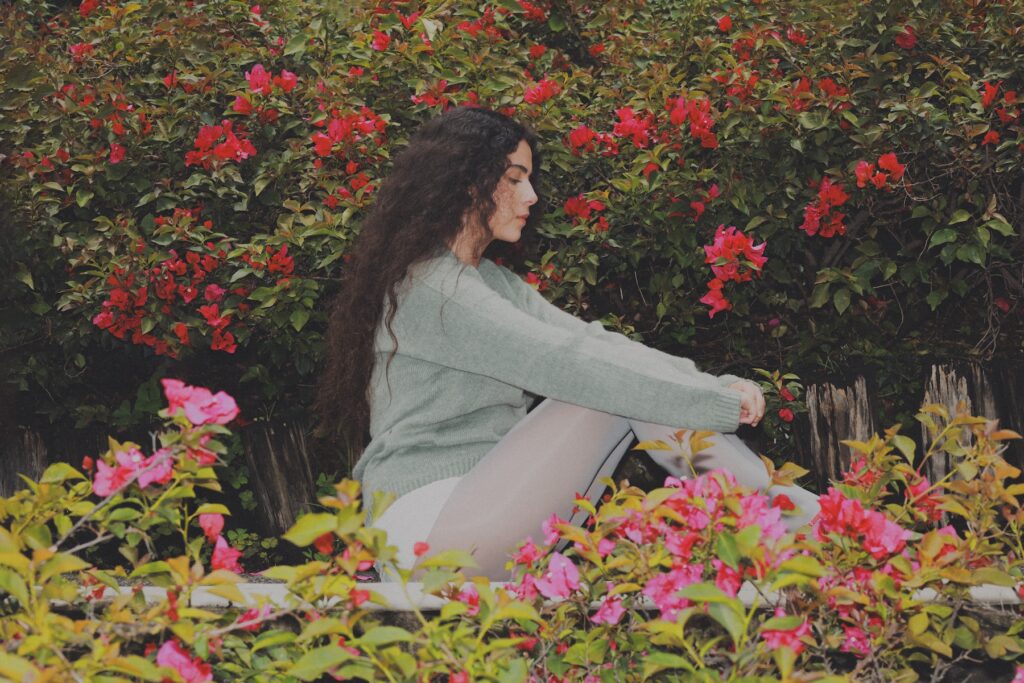 La cantante veracruzana sentada en medio de un jardín.