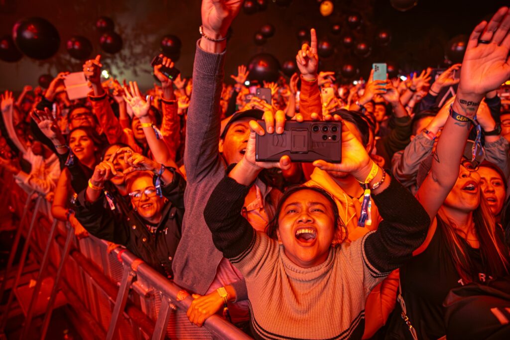Asistentes a festival de música gritando y cantando.