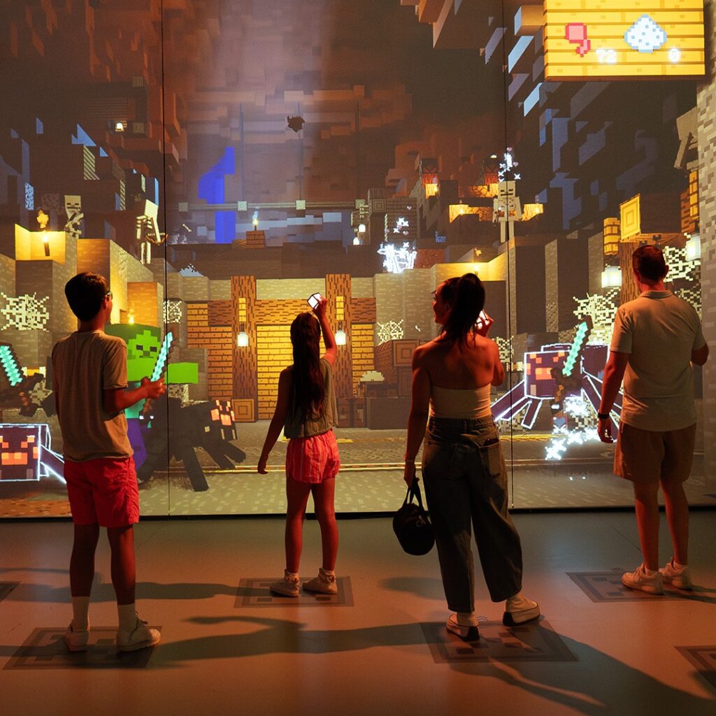 Adultos y niños jugando en experiencia inmersiva de Minecraft.