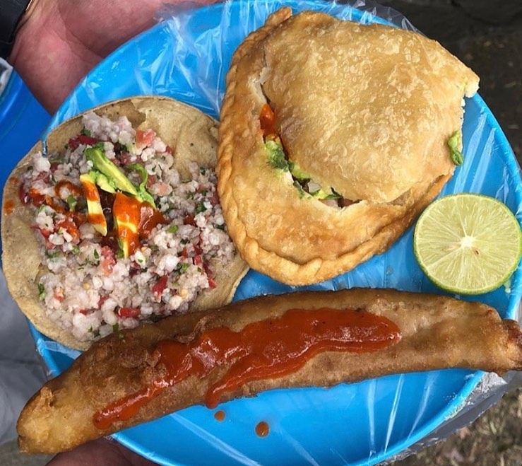 Un trío clásico de banqueta: tostada de ceviche picado, empanada frita y pescadillo rebozado con salsa.