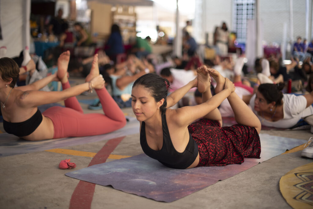 mujer haciendo una postura de yoga durante una clase.