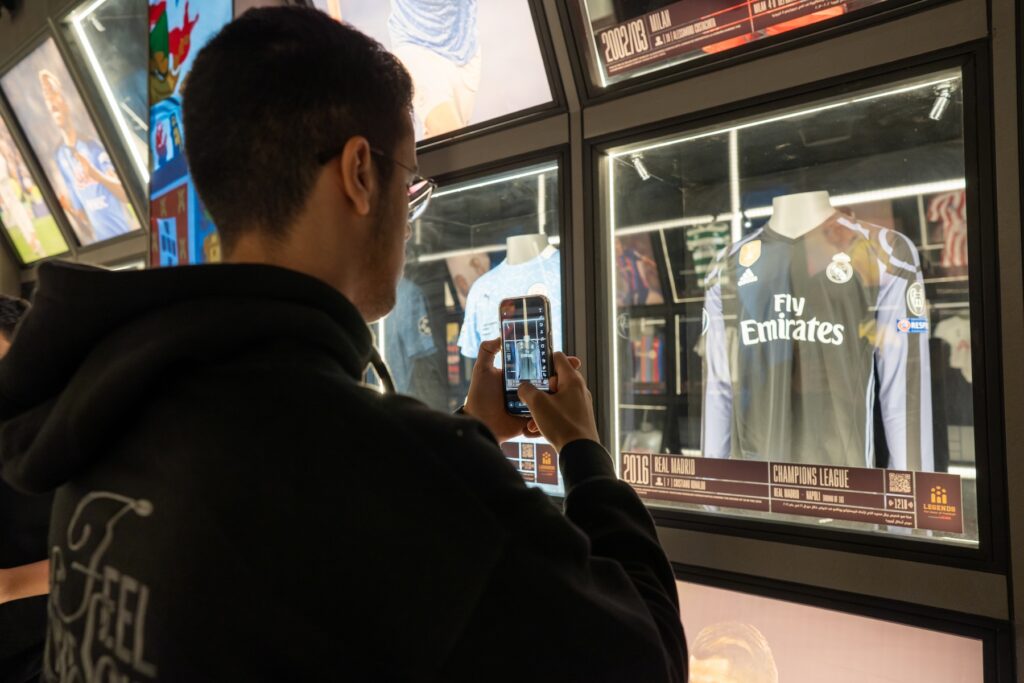 Joven tomando foto a jersey en la experiencia de futbol en CDMX.