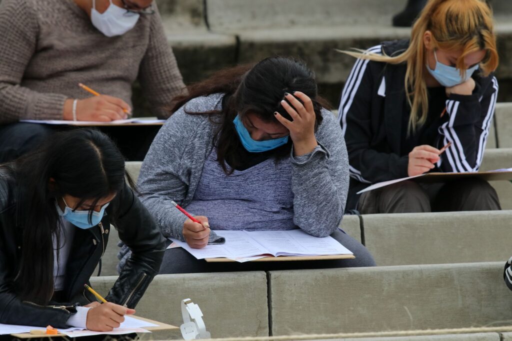 joven haciendo su examen de admisión para ingresar al Nivel Superior en la UNAM, en el Estadio Olímpico Universitario