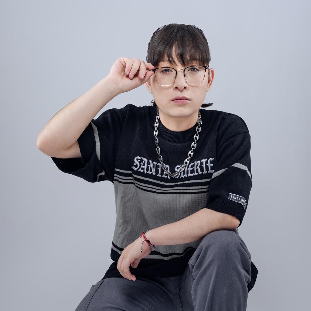 Azuki, una de las raperas que acompañará a Residente en el Zócalo, usando una playera negro con gris y sostenido sus lentes.