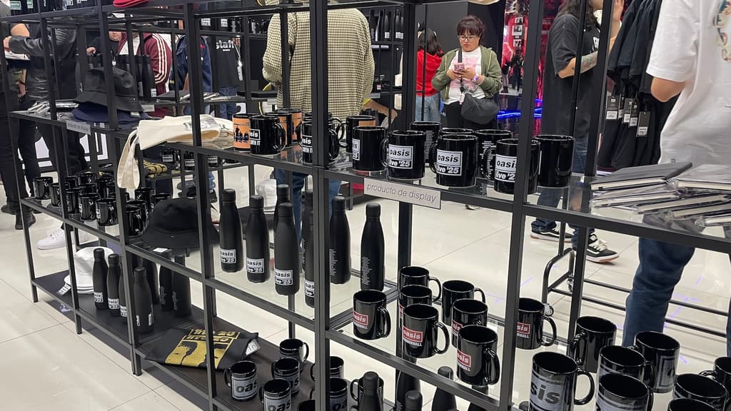Tazas y termos dentro de la tienda de fans de Oasis en CDMX.
