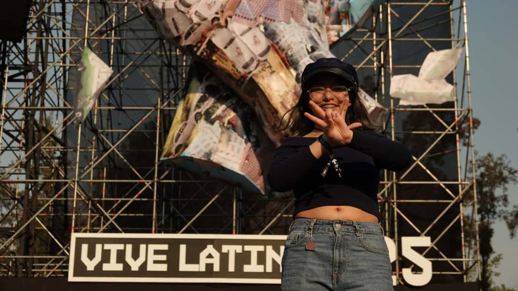 Asistente al festival Vive Latino haciendo las letras V y L con sus manos.