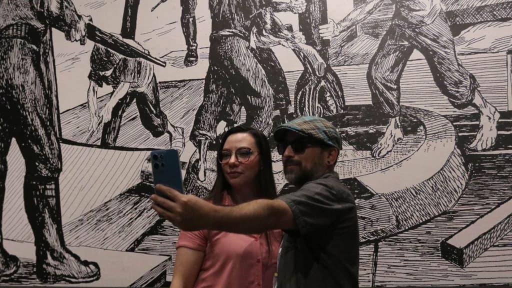 Pareja tomándose selfie frente a una obra en el Museo Nacional de la Estampa.