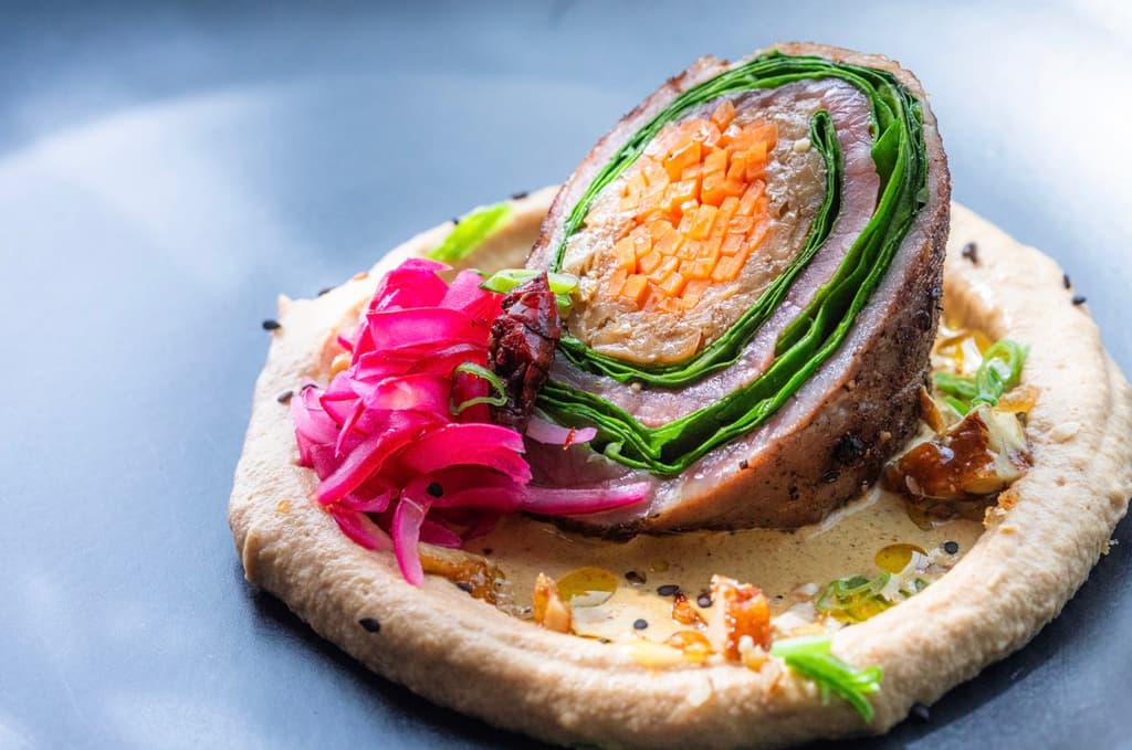 Tampiqueña rellena de setas, zanahora y acelgas, acompañada con puré de coliflor, manzana verde y salsa cremosa de chapulín.