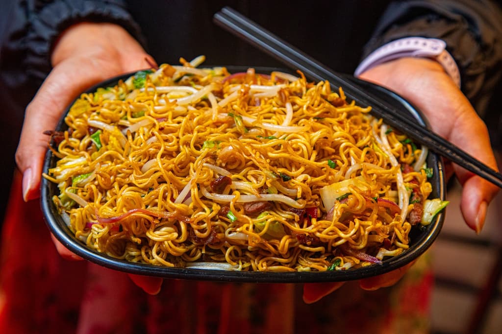 Plato de noddles con verduras y carne, parte de la oferta de comida asiática.