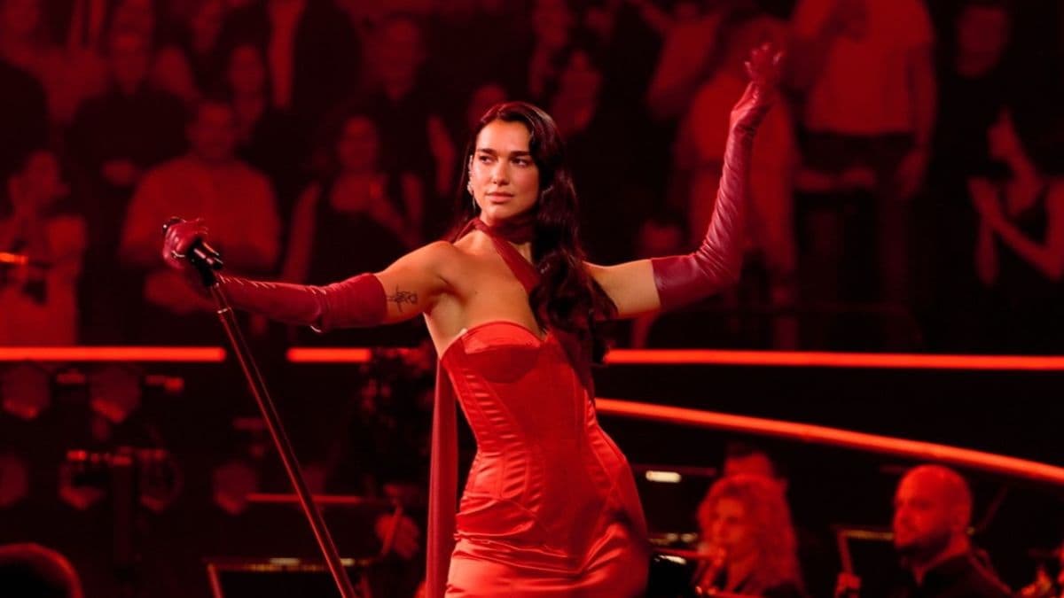 Dua Lipa en concierto usando un vestido rojo.