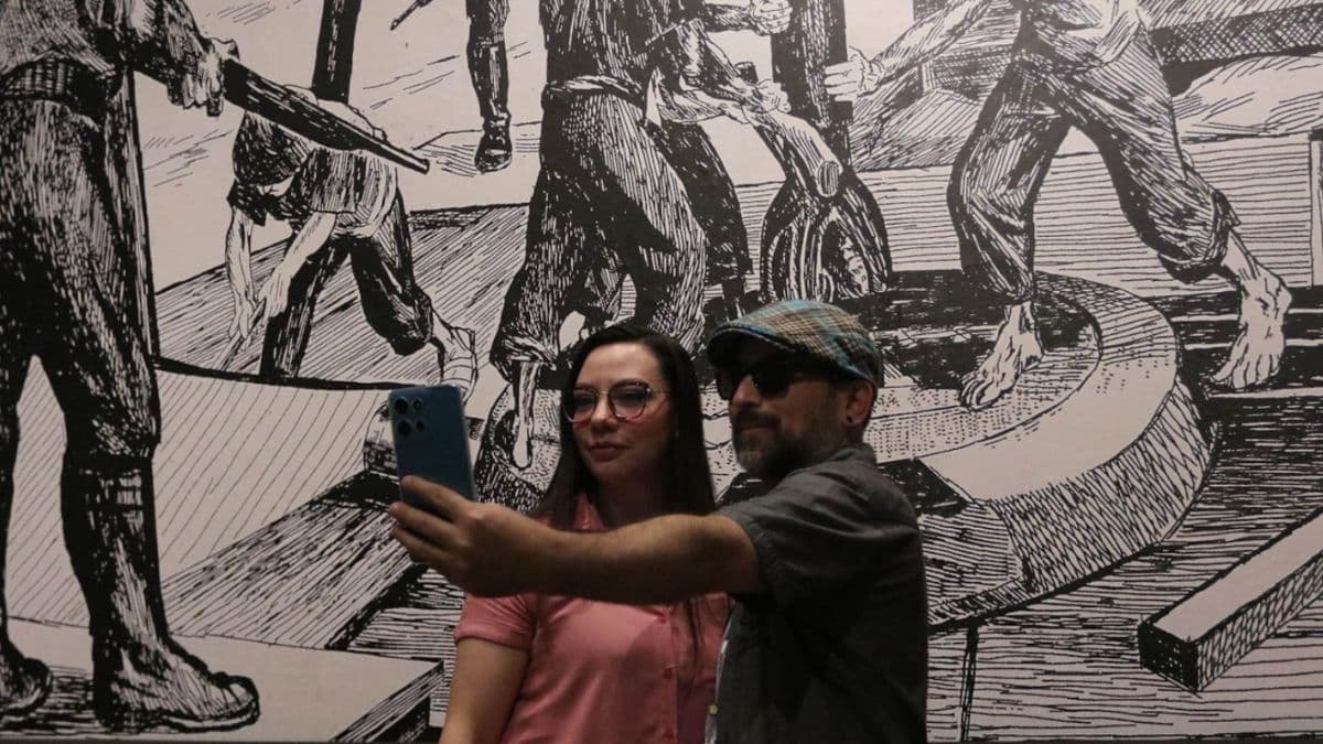 Pareja tomándose selfie frente a una obra en el Museo Nacional de la Estampa.