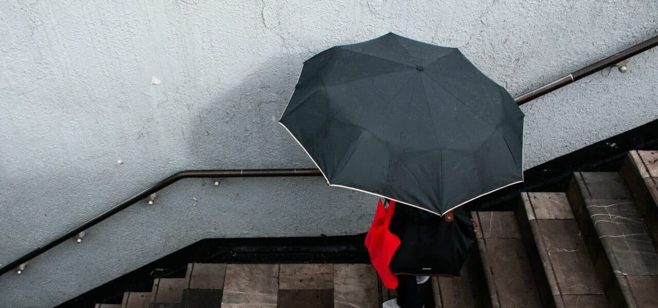 Una mujer entra al metro Centro Médico protegiéndose de la lluvia con un paraguas. Foto: Cuartoscuro